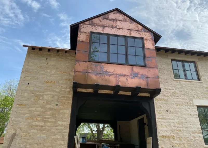 Copper metal panel facade on a stone building for Metal Roof Coating in Wedgefield